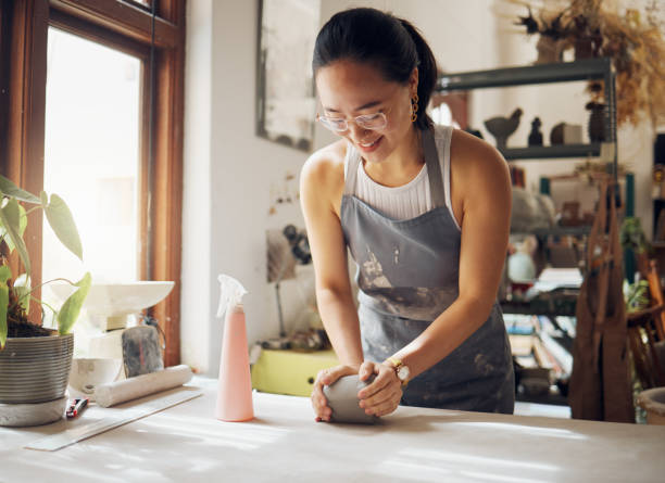 istock Happy, pottery and woman in workshop with clay for creativity, inspiration and art process. Creative asian small business girl working at artistic workspace with excited smile in Tokyo, Japan 1473193946