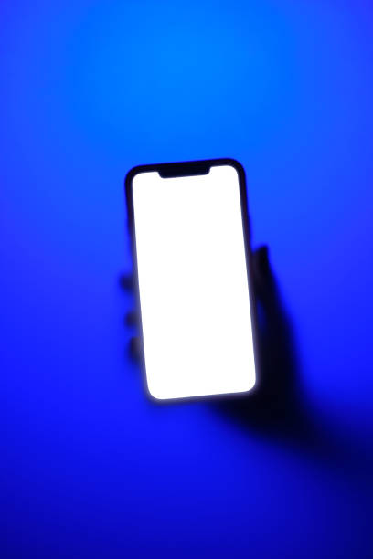 istock Phone in hand in neon blue fog 1473195015