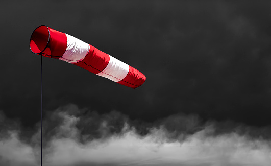 Wind vane in front of a stormy sky