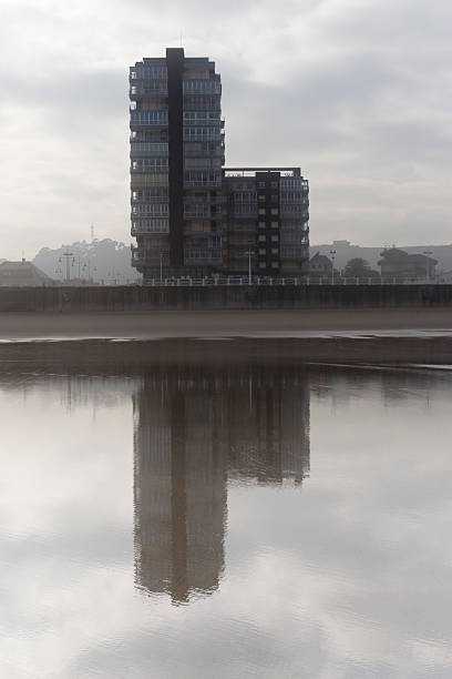 La costa de la ciudad, se refleja en la playa - foto de stock