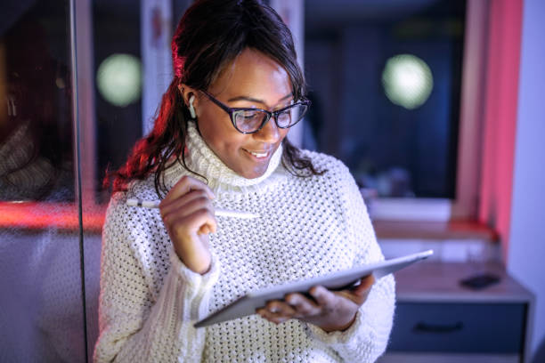 istock Well dressed businesswoman using digital tablet in home office late night 1473196215