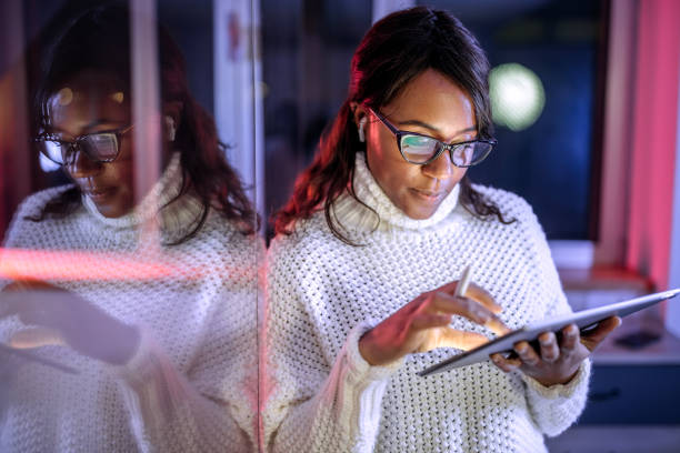 istock Well dressed businesswoman using digital tablet in home office late night 1473196228