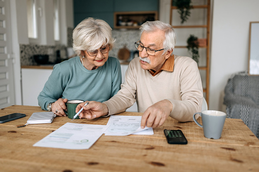 Mature couple going over financial bills in their domestic kitchen