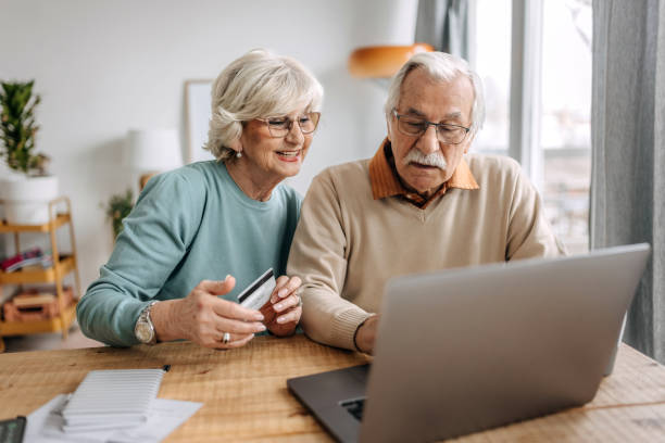istock Old couple shopping online at home using laptop 1473197707