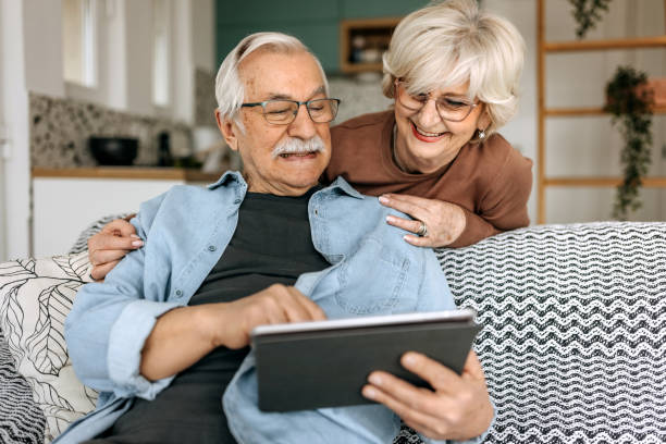 istock Happy senior couple using digital tablet together at home 1473197914