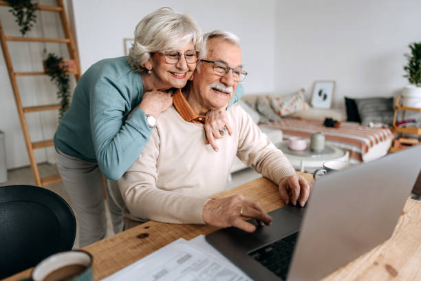 istock Senior happy couple embracing using laptop together 1473198136