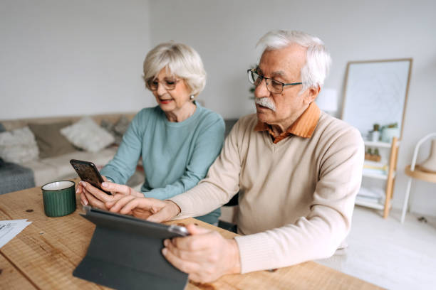istock Senior couple using a digital tablet and phone at home 1473198249