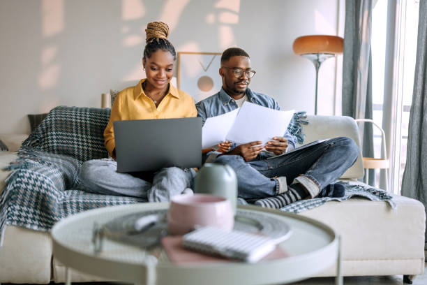 istock Young smiling couple working from home, going over paperwork 1473199779