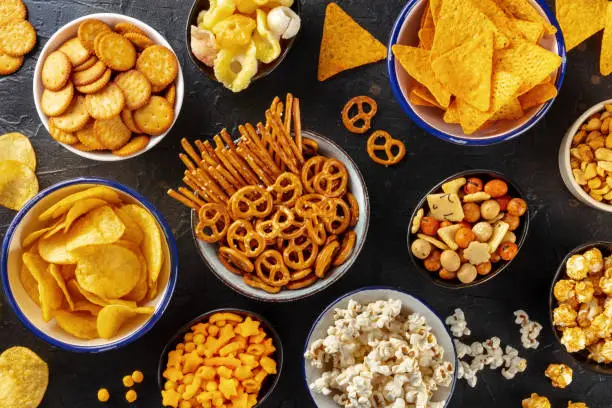 Photo of Salty snacks, party mix. An assortment of crispy appetizers, overhead