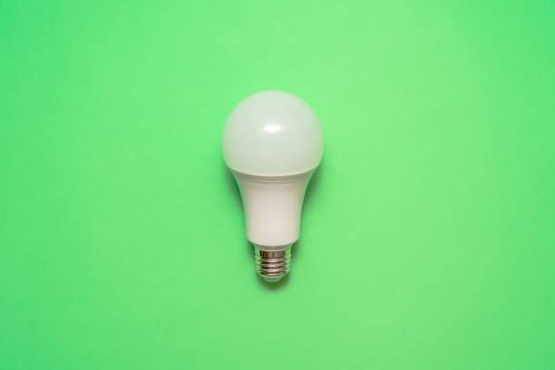 istock Energy saving light bulb on green background. Savings 1473200121