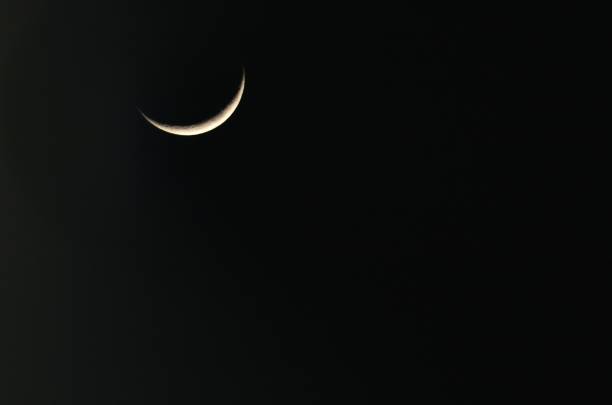 A crescent moon with black sky in background