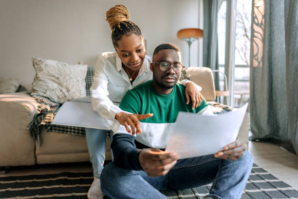 istock Couple analysing bills at home together 1473200471