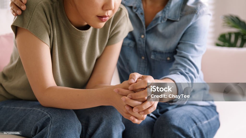 Middle aged asia people old mom holding hands trust comfort help young woman talk crying stress relief at home. Mum as friend love care hold hand adult child feel pain sad worry of life crisis issues. Mental Health Stock Photo