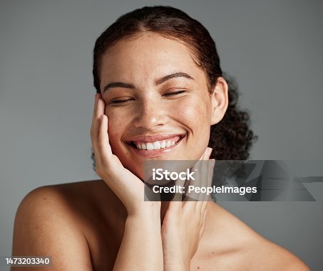 istock Face, beauty and satisfaction with a model black woman in studio on a gray background to promote natural skincare. Facial, wellness and makeup with an attractive young female happy with cosmetics 1473203340