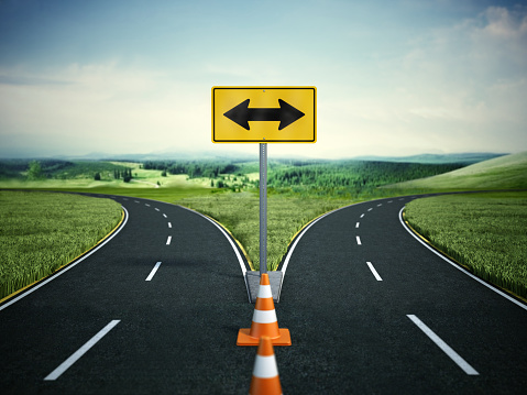 Splitting road with arrow sign pointing left and right. Choice and decisions concept