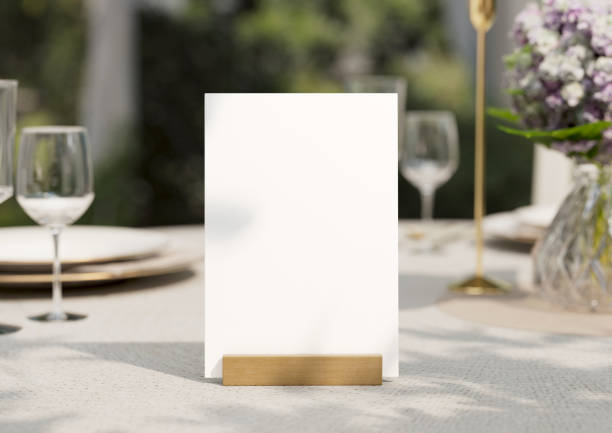 istock Mockup white blank space card, for greeting, table number, wedding invitation template on wedding table setting background. with clipping path. 1473204650