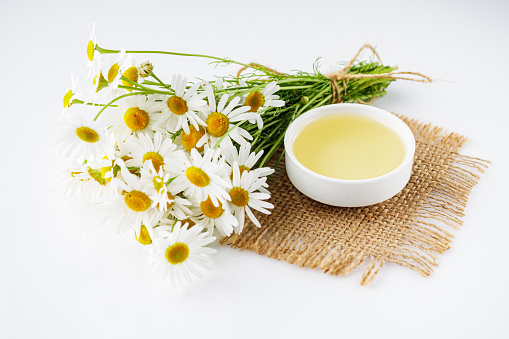 aromatic chamomile essential oil on a white background.