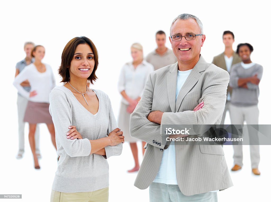 Hombre de negocios de pie con mujer joven - Foto de stock de Director ejecutivo de empresa libre de derechos