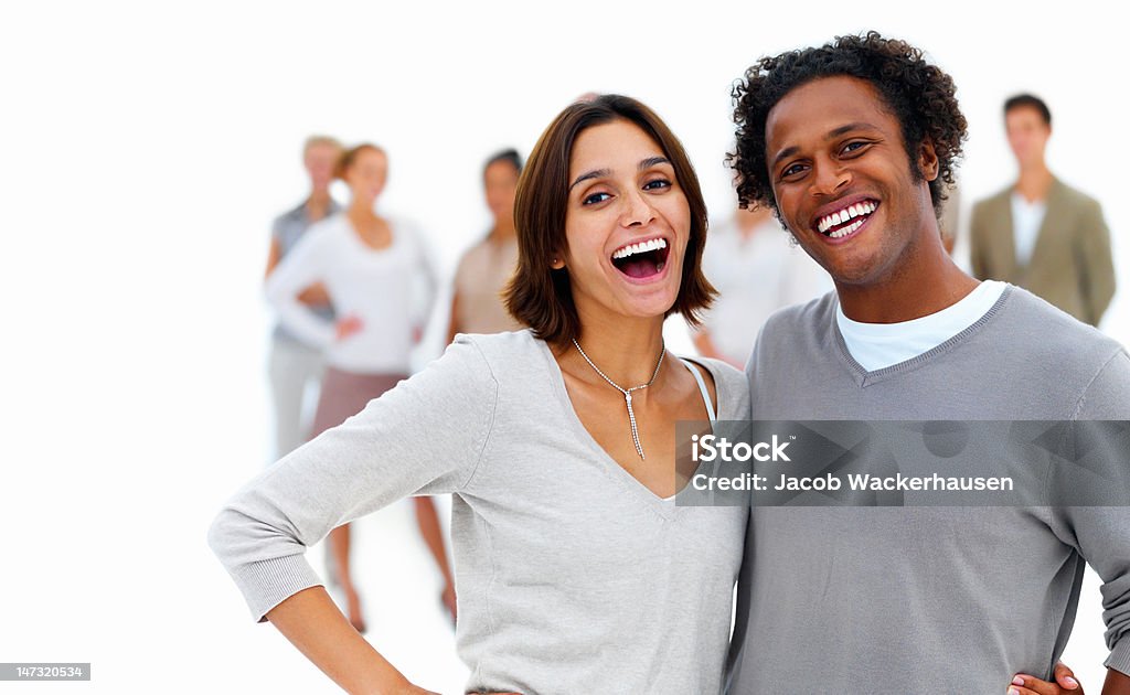Счастливая молодая пара с друзьями на заднем плане - Стоковые фото 20-24 года роялти-фри