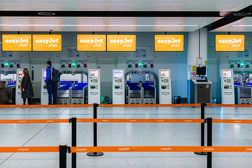 Gatwick, UK - 12 March, 2023: people using the EasyJet self-service check-in machines inside the north terminal at Gatwick Airport, UK.