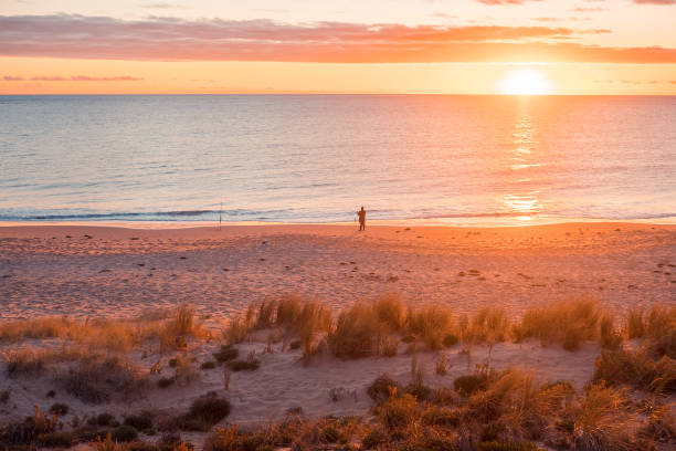 Fisherman's silhouette on Christies Beach at sunset, South Australia
