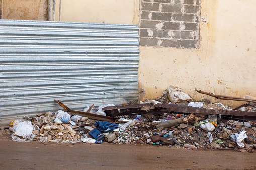 Havana, Cuba - January 24, 2023: A refuse heap on the street beside a building. An aluminum pan is at the back of the waste dump; no people are on the scene.