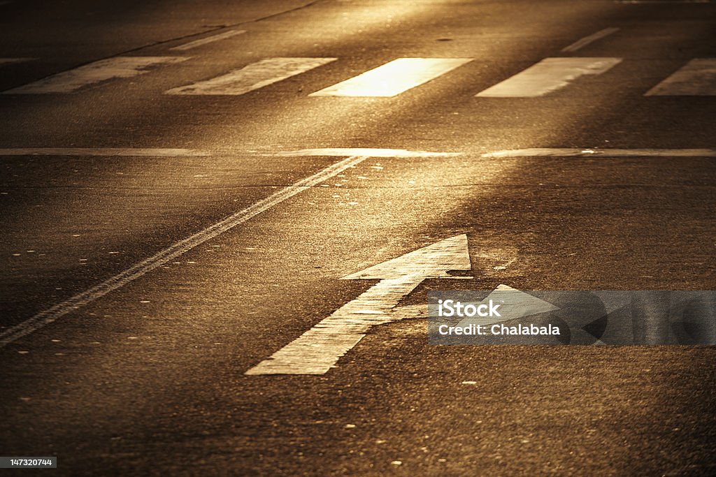 Arrow sign Arrow on the asphalt road at sunlight. Arrow Symbol Stock Photo