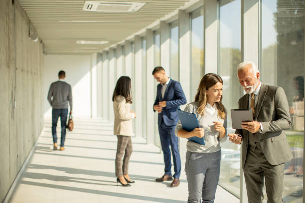 istock Modern business people using digital tablet in the office corridor 1473208243