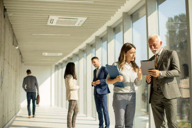 istock Modern business people using digital tablet in the office corridor 1473208247