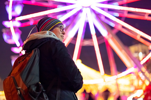 Woman using smartphone in front of ferris wheel