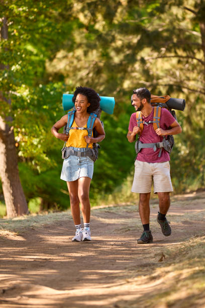 istock Couple With Backpacks On Vacation Hiking Through Forest Countryside Together 1473209507