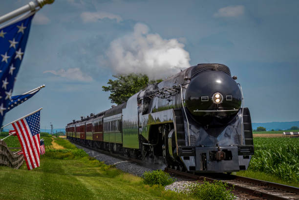 istock A Restored Steam Passenger Train Approaches As American Flags Wave on a Fence 1473210470