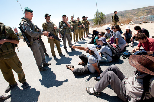 Al-Walaja, Occupied Palestinian Territories - August 27, 2011: Israeli, Palestinian, and international activists confront Israeli soldiers and police in a protest against the encirclement of the West Bank town of Al-Walaja by the Israeli separation barrier.