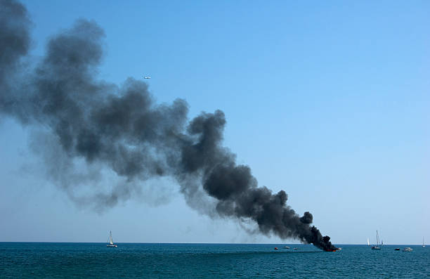 Burning sailboat in the sea stock photo