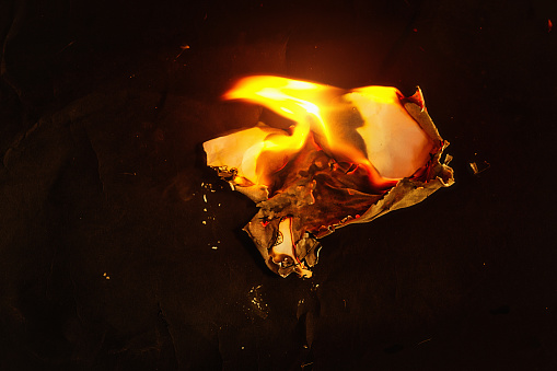 Burning remnants of a piece of paper.