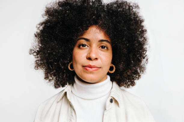 istock Self-confident woman with curly hair looking at the camera in a studio 1473214284