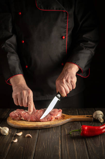 istock A professional chef cuts raw veal meat on a cutting board before baking. Asian cuisine. Cooking delicious food in the kitchen. 1473216220