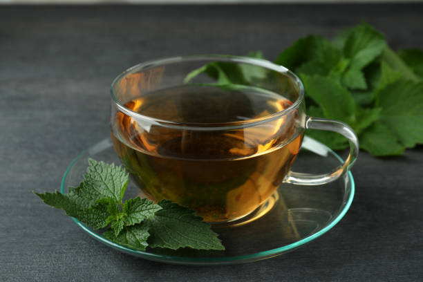istock Cup of nettle tea on dark wooden table 1473218056