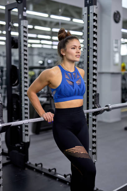 istock Slim, bodybuilder female have rest after training with heavy weight, posing in gym 1473218530