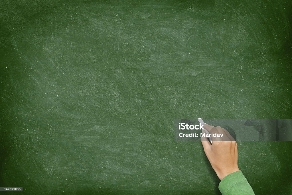 Blank Blackboard / Chalkboard with Hand Blank blackboard / chalkboard. Hand writing on green chalk board holding chalk. Great texture for text. See more: Chalkboard - Visual Aid Stock Photo