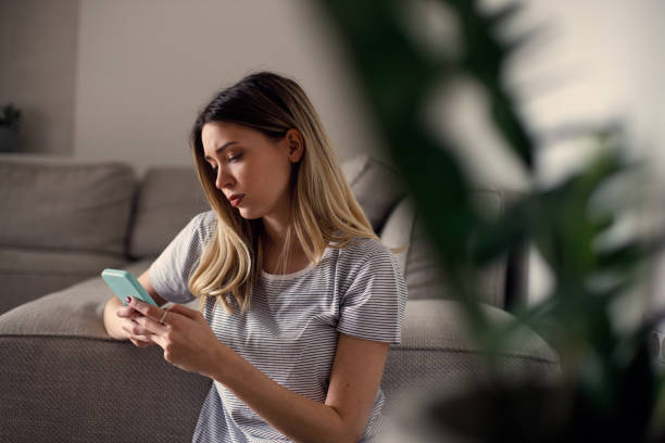 istock Serious thoughtful young woman holding smartphone 1473221219