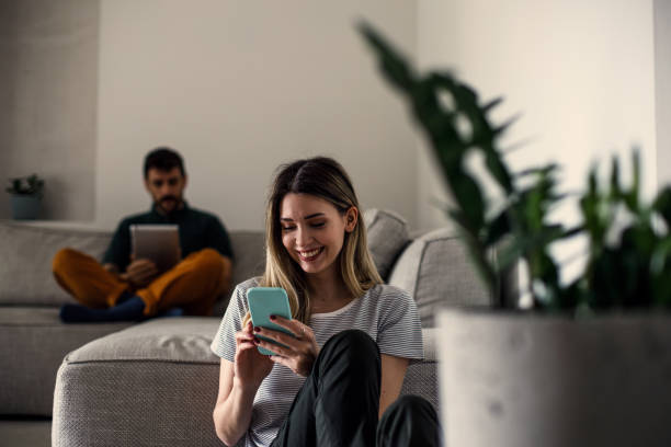 istock Couple using their phones at home 1473221457