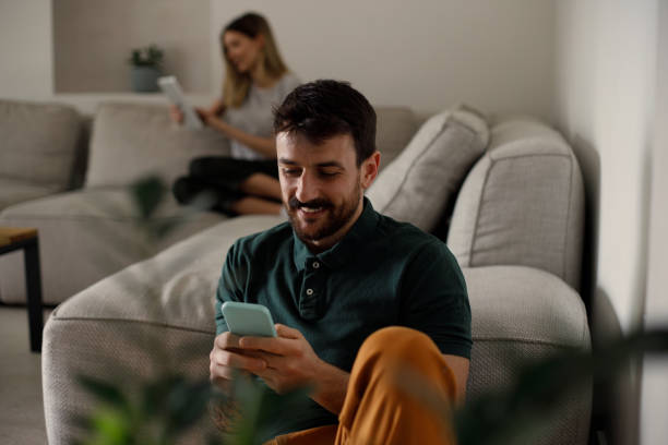 istock Couple using their phones at home 1473221898