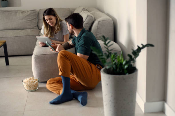 istock Couple using their phones at home 1473222896