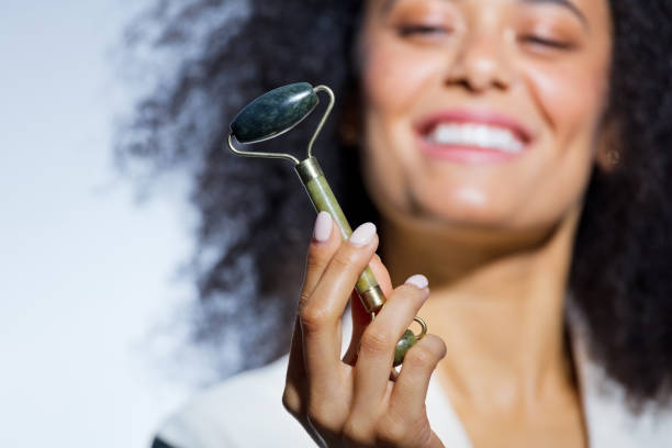 istock Beautiful woman holding jade roller 1473224110