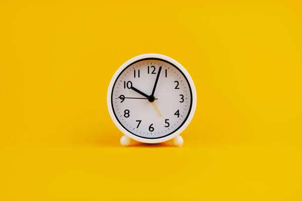 istock white clock on yellow background concept of time Time planning 1473225495