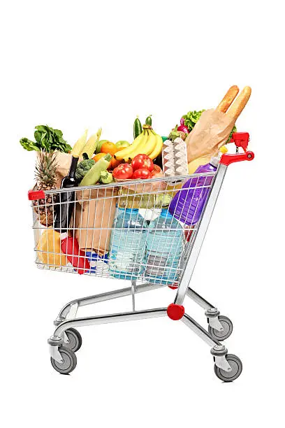 A shopping cart full with groceries isolated on white background