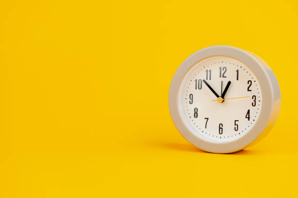 istock white clock on yellow background concept of time time is important to work 1473227583