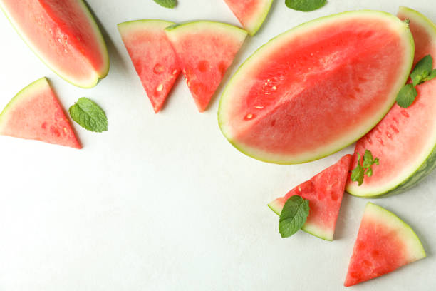 istock Watermelon slices and mint leaves on white textured table 1473228950