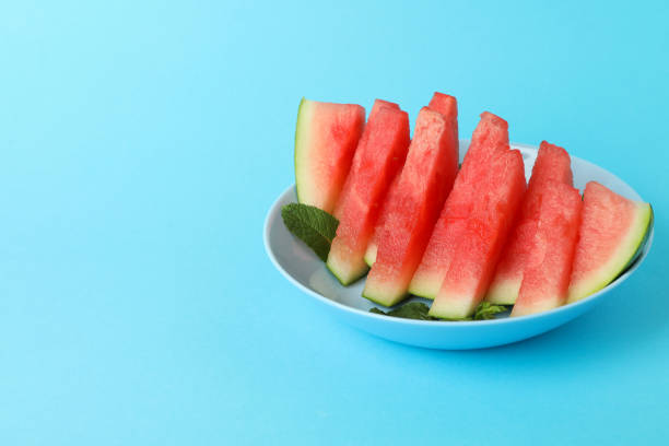 istock Plate with watermelon slices and mint leaves on blue background 1473229658
